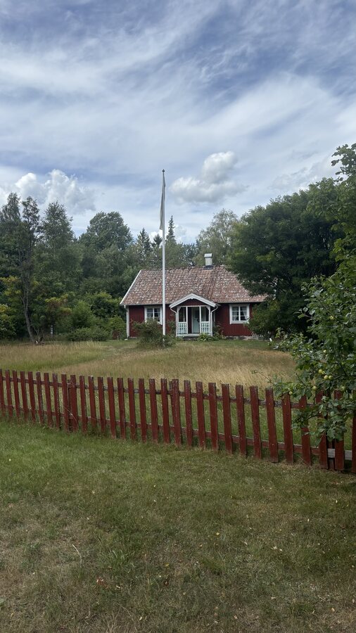 Rotes Schwedenhaus mit Flaggenmast, erinnert an Michel aus Lönneberga